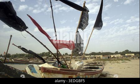 Rustikale Fischerboote mit bunten Fahnen, Bojen am Strand, Balau Sky, Cap Skirring, Casamance, Senegal Stockfoto