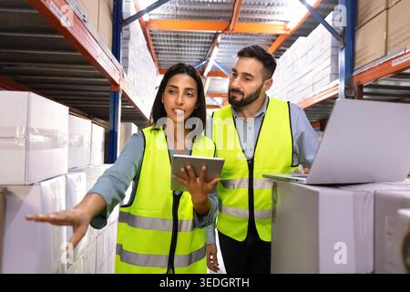 Zwei Logistikmitarbeiter diskutieren über Lagerbestand im Lager Stockfoto