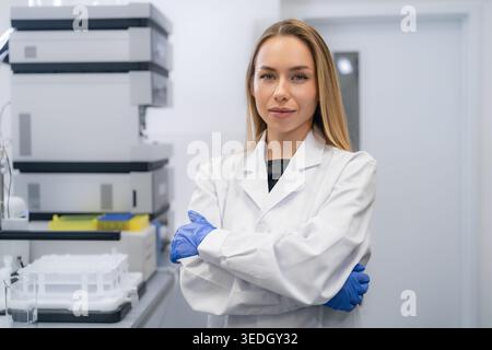 Labortechniker mit gekreuzten Armen im modernen klinischen Forschungsumfeld. Stockfoto