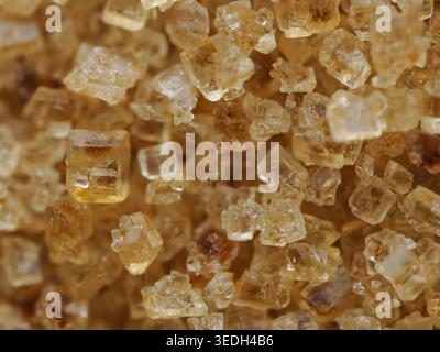 Extreme Makrostruktur aus braunen Zuckerkristallen, detaillierte Essensstruktur Stockfoto