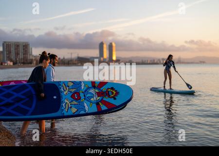 Ein paar Touristen, junger Mann und Frau, die Spaß beim Paddeln auf dem Meer haben Stockfoto