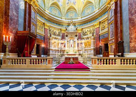 Im Inneren der Stephansbasilika in Budapest ist der Altar mit Kerzen und Dekorationen zu sehen. Besucher können Details zur Architektur sehen. Stockfoto