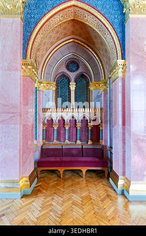 Die Menschen besuchen die architektonischen Details des ungarischen Parlaments in Budapest. Der Innenraum zeigt Sitze und dekoratives Design. Stockfoto