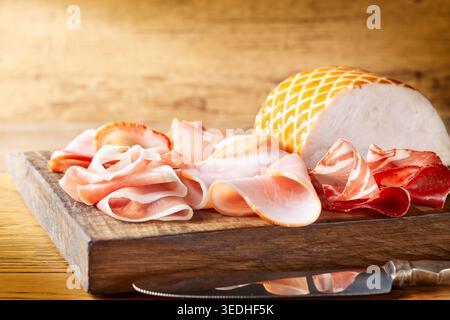 Eine Auswahl von Marmelade, Salami, Schinken auf hölzernem Hintergrund. Verschiedene Fleischvorspeisen. Stockfoto