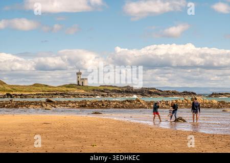 Die Leute am Elie Beach mit dem Leuchtturm von Elie Ness im Hintergrund. East Neuk of Fife, Schottland. Stockfoto
