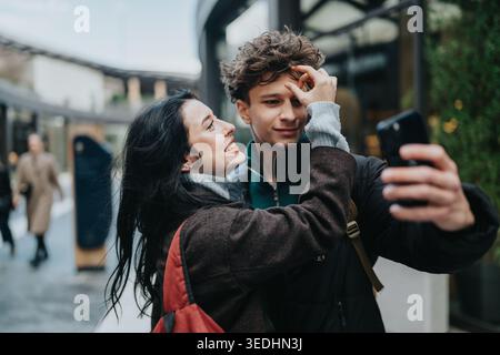 Highschool-Freunde machen gemeinsam ein verspieltes Outdoor-Selfie in einer urbanen Straßenumgebung Stockfoto