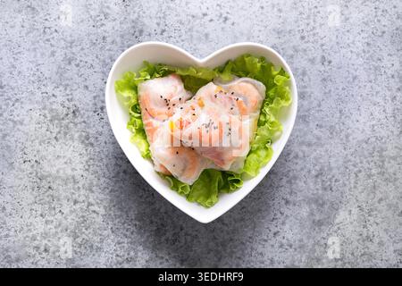 Vietnamesische Frühlingsrollen mit Gemüse, Garnelen in Reispapier auf grauem Steingrund. Ansicht von oben. Asiatische Küche. Stockfoto