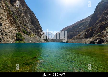 Ein wunderschöner türkisfarbener Bergsee in den Fan Mountains, mit kristallklarem Wasser, das die umliegenden Gipfel reflektiert. Stockfoto