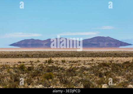 Eine beeindruckende atmosphärische Fata Morgana verzerrt die Silhouette der fernen Berge über dem Salar de Uyuni, der weltweit größten Salzebene im Poto Stockfoto