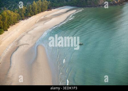 Blick aus der Vogelperspektive auf das wunderschöne Meer und den Strand Thailand mit klarem grünem Meer, weißem Sand, kleines Boot, das in der Nähe der ruhigen Küste schwimmt und eine ruhige Atmosphäre schafft Stockfoto