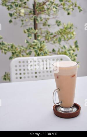 Im kopitiam-Stil geeiste tarik serviert in einem hohen Glas auf einem weißen Tisch Stockfoto
