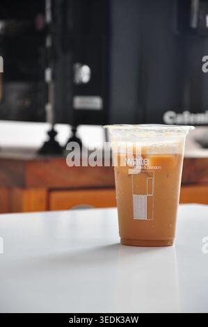 Eismilchkaffee mit braunem Zucker in einem verschlossenen Plastikbecher zum Mitnehmen Stockfoto