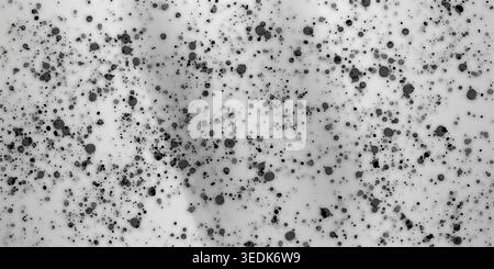 Ein minimalistischer abstrakter Hintergrund mit einem Muster aus verstreuten schwarzen Tintenspritzern und Punkten auf einer sauberen, einfarbigen weißen Oberfläche. Stockfoto