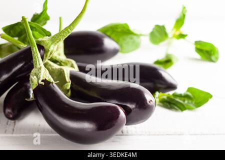 Frische Auberginen auf einem weißen Holztisch. Konzept der gesunden Ernährung, frisches Gemüse. Stockfoto