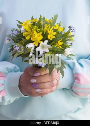 Ein Strauß wilder Blumen in den Händen einer Frau Stockfoto