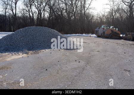 Baustelle mit Schotterhaufen und Maschinen auf der Straße, Konzept der Infrastruktur, Straßenreparatur und Baumaterialien. Stockfoto