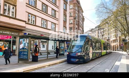 Straßburg, Frankreich - 11. April 2022: Moderne elektrische Straßenbahn nähert sich einer Straßenbahnhaltestelle im Zentrum von Straßburg Stockfoto