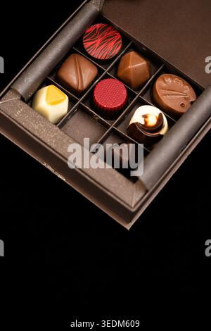 Nahaufnahme ausgewählter Gourmet-Schokoladentrüffel in eleganter Geschenkverpackung, vertikales Bild Stockfoto