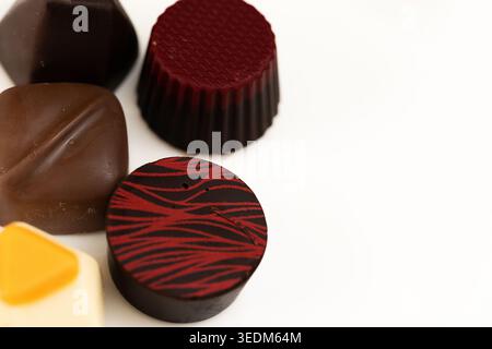 Verschiedene Gourmet-Schokoladen-Pralinen mit künstlerischen Designs auf weißem Hintergrund Stockfoto
