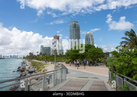 Sonniger Fußweg am South Pointe Park Pier mit Palmen und luxuriösen Hochhäusern in Miami Beach, Florida. Stockfoto