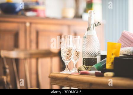 Eine Flasche Champagner und zwei Gläser stehen auf einem Tisch, was auf einen besonderen Anlass oder eine besondere Veranstaltung hindeutet Stockfoto