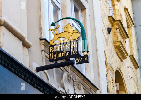 Prag, Tschechische Republik - 12. November 2015: Das kunstvoll verzierte goldene Löwenschild für das Restaurant U Zlateho lva hängt an einer historischen Gebäudefassade, dem Golde Stockfoto