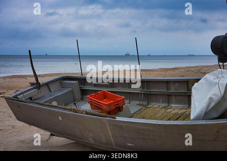 Fischerboot am herbstlichen Sandstrand von Baabe auf Rügen; Blick über die Ostsee unter dramatischem Himmel in Norddeutschland Stockfoto
