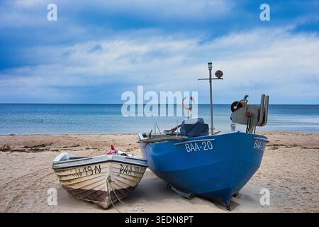 Klassische Fischerboote am Sandstrand von Baabe auf Rügen; maritime Szene auf der Ostsee unter bewölktem Himmel, Norddeutschland Stockfoto