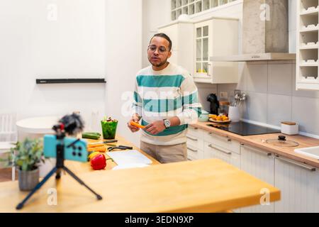 Mann Vlogging Hauskochen Tutorial in moderner Küche Stockfoto