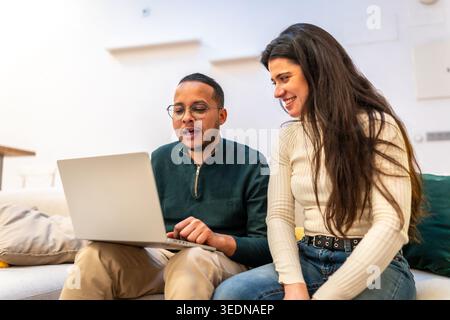 Verschiedene Paare diskutieren Ideen, während sie ein Notebook gemeinsam nutzen Stockfoto