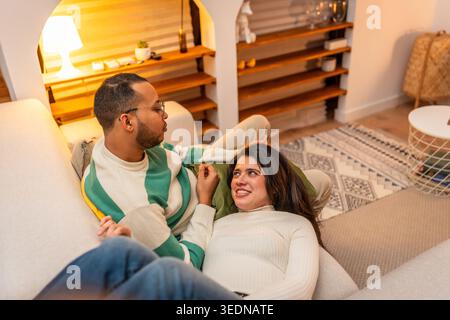 Glückliches junges Paar, das sich zu Hause auf dem Sofa entspannt Stockfoto
