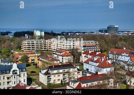 Blick aus der Vogelperspektive auf eine Wohngegend am Meer mit roten Dächern, Hotels, Apartments und Meerblick - die Küstenstadt Świnoujście. Stockfoto