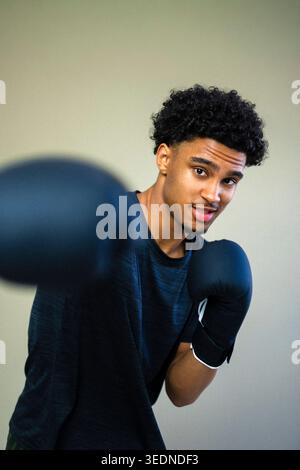Porträt eines jungen Mannes, der Boxen vor farbigem Hintergrund übt Stockfoto