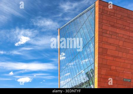 Danzig, Polen - 3. Mai 2025: Das Museum des Zweiten Weltkriegs. Zeitgenössische Architektur mit Glas und rotbraunen Fliesen im Kontrast zu einem lebendigen Stockfoto