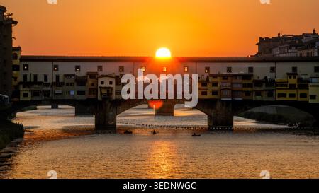 Sonnenuntergang hinter dem berühmten Ponte Vecchio über dem Fluss Arno in Florenz, Italien Stockfoto