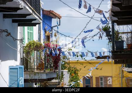 Griechische Fahnen hängen auf Balkonen im mediterranen Dorf Stockfoto