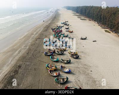 Cox's Bazar, Bangladesch - 10. März 2026: Aus der Vogelperspektive auf traditionelle farbenfrohe Mondboote, die am Sandstrand des längsten natürlichen Meeres der Welt parken Stockfoto