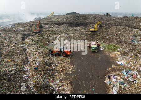 Aminbazar, Bangladesch - 26. Januar 2025: Luftaufnahme der Aminbazar-Deponie mit Baggern und Arbeitern, die sich durch riesige Müllhaufen bewegen Stockfoto