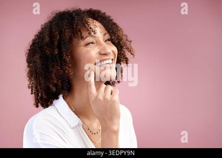 Frau, natürlich und denkend im Studio für Haarpflege, Wachstum und Textur mit Mockup-Raum. Glückliche Person, lockiges Haar und Idee auf rosa Hintergrund für Stockfoto