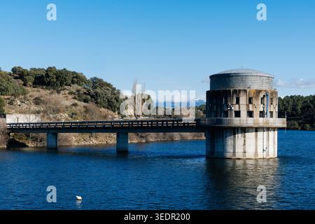 Der im Stausee stehende Einlassturm des El-Villar-Staudamms, der durch eine Brücke verbunden ist, dient der Wasserwirtschaft für Madrid Stockfoto