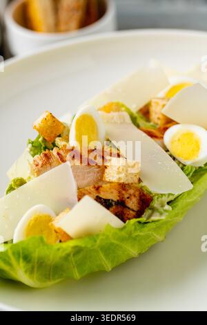 Caesar Salat mit Hühnchen und Eiern in moderner Platte Stockfoto