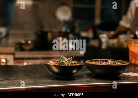 Asiatische Nudelschüsseln werden an der Restauranttheke in moderner Küche serviert. Hochwertige Fotos Stockfoto
