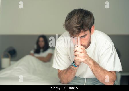 Ein verärgerter Mann und eine verärgerte Frau wenden sich im Bett nach einer ernsthaften Meinungsverschiedenheit voneinander ab und zeigen Frustration, Bedauern und die Belastung ungelöster Konflikte zu Hause Stockfoto