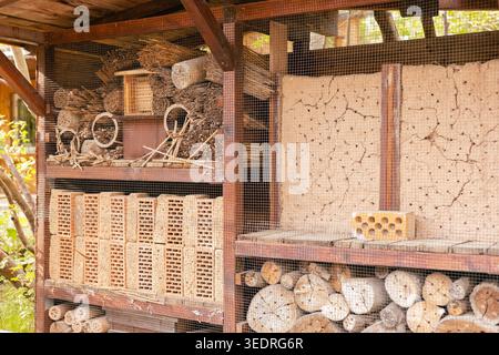 Das Insektenhotel steht in einem Garten, der aus Holz und Lehm gebaut ist. Sie bietet Bienen, Käfern und anderen Insekten Lebensraum, um sich zu nisten und Unterschlupf zu finden. Die St Stockfoto