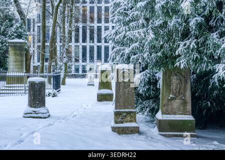 Schneebedeckter historischer Friedhof und Grabsteine in Düsseldorf Golzheim Stockfoto