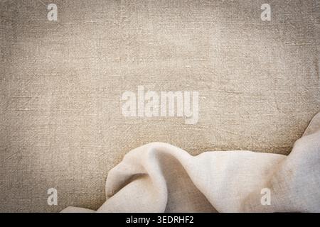 Hellbeige Leinenstoff mit Falten und natürlicher Textur. Naturfarbener Hintergrund für Produktpräsentationen und Hochzeiten. Stockfoto