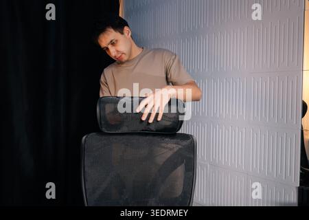 Man stellt die Kopfstütze des ergonomischen Bürostuhls für optimalen Komfort und Halt ein und konzentriert sich dabei auf die richtige Körperhaltung und die Einrichtung des Arbeitsplatzes im Profi Stockfoto