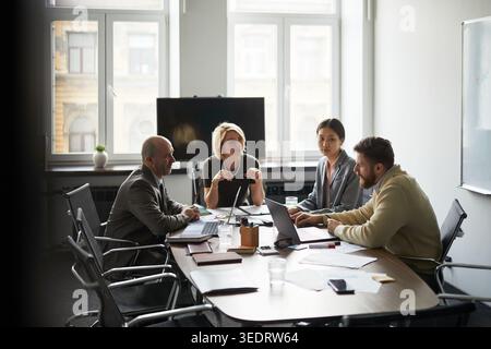 Umfassende Aufnahme von Besprechungen mit verschiedenen Geschäftsteams im Büro, bei denen die Strategie rund um Notebooks und Dokumente diskutiert wurde. Unternehmenskonzept für Teamarbeit, Führung, Beratung, Kommunikation Stockfoto