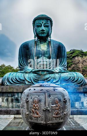 KAMAKURA, JAPAN - 24. DEZEMBER 2025: Eine große Räucherurne mit Rauch steht vor dem riesigen bronzenen Daibatsu oder riesigen Buddha im Shojosen-JI; Stockfoto