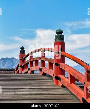 ITSUKUSHIMA, JAPAN, 30. DEZEMBER 2025: Eine alte Holzbrücke in Itsukushima stellt einen Kreuzungspunkt über einen kleinen Fluss in Miyajima dar. Stockfoto